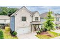 Charming two-story home with white brick, an attached garage, landscaped yard, and inviting covered front porch at 1250 Grove Pkwy, Jonesboro, GA 30236