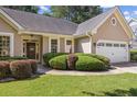 Close-up of the front yard featuring the front door, trimmed hedges, and a two-car garage at 3072 Oaktree Ln, Duluth, GA 30096