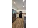 Modern kitchen with stainless steel appliances, white cabinetry, light countertops, and wood-look tile flooring at 776 Tulip Poplar Way, Lawrenceville, GA 30044