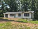 Charming one-story home with a landscaped front yard and dark shutters, surrounded by mature trees at 1087 W Adrian Sw Cir, Conyers, GA 30094