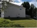 Angled side view of the house with a fenced in back yard and manicured lawn at 857 Asbury Trl, Lithonia, GA 30058