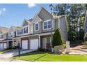 Street view of a two-story townhome showing landscaping, brick accents, and inviting curb appeal at 3170 Cedar Glade Ln, Buford, GA 30519
