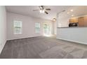 Spacious living room with carpet, multiple windows, and views of the kitchen and backyard at 3170 Cedar Glade Ln, Buford, GA 30519