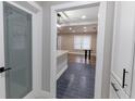 Modern hallway with view to the open concept room, featuring dark tile floors, laundry door, and storage at 1174 Donnelly Sw Ave, Atlanta, GA 30310
