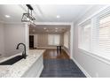 Stylish kitchen featuring granite countertops, black faucet, and modern pendant lighting open to a dining area at 1174 Donnelly Sw Ave, Atlanta, GA 30310