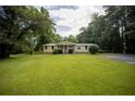 Well-maintained front yard and charming yellow house with covered porch and easy driveway access at 1205 Humphries Nw Rd, Conyers, GA 30012