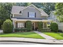 Charming two-story home with landscaped front yard and classic architectural details and green siding at 2213 Parkview Nw Ct, Atlanta, GA 30318
