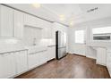 Bright white kitchen features stainless appliances, wood floors, and stylish backsplash at 837 Serramonte Dr, Marietta, GA 30068