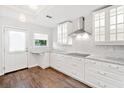 Bright white kitchen features stainless appliances, wood floors, and stylish backsplash at 837 Serramonte Dr, Marietta, GA 30068