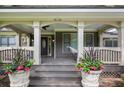 Charming covered front porch adorned with stylish columns, planters, and a cozy hammock at 1665 Cunningham Road Southwest Sw Rd, Marietta, GA 30008