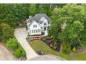 Aerial view of home showcasing landscaped yard, long driveway, and wooded surroundings at 2184 Summerchase Dr, Woodstock, GA 30189