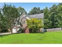 Inviting home exterior featuring a well-manicured lawn and mature trees that provide shade and curb appeal at 346 Majestic Run, Temple, GA 30179