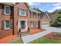 Inviting brick home featuring a classic entrance with a storm door, and a two-car garage at 1079 Angel Ln, Powder Springs, GA 30127