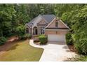 Inviting brick home nestled among mature trees, showcasing a well-maintained lawn and a spacious driveway at 8189 N Pine Cone N Dr, Villa Rica, GA 30180