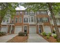 Exterior of a brick townhome with garage, black front door, and nice landscaping at 2160 Dillard Xing, Tucker, GA 30084