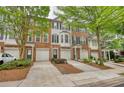 Brick townhome featuring an attached garage, well-kept landscaping, and charming architectural details at 2160 Dillard Xing, Tucker, GA 30084