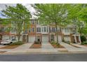Exterior view of a brick townhome with a garage, well-manicured lawn, and traditional design at 2160 Dillard Xing, Tucker, GA 30084