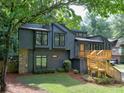 A stylish contemporary home featuring dark siding, natural wood accents, and a beautifully landscaped front yard at 2540 Rocky Springs Dr, Marietta, GA 30062