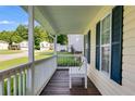 Inviting covered front porch features a white bench, perfect for relaxing and enjoying the outdoors at 604 Meadows Ct, Villa Rica, GA 30180
