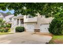 View of a two-story house with a well-kept lawn, two-car garage, and mature landscaping at 7125 Creeksong Dr, Douglasville, GA 30134