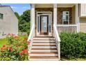 Close-up of front steps with white railings, stone accents, and blooming flowers, creating a welcoming entrance at 7125 Creeksong Dr, Douglasville, GA 30134