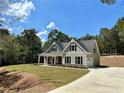 Stylish two-story home with an attached garage and a paved driveway against a wooded backdrop at 22 Stratford Way, Kingston, GA 30145