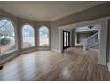 Spacious living room with large windows offering great views and hardwood floors with elegant trim at 7910 Tintern Trce, Duluth, GA 30097