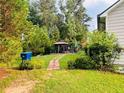 Private backyard oasis with a gazebo, brick pathway, and lush greenery, perfect for outdoor relaxation at 3545 Renaissance Cir, Atlanta, GA 30349