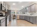Modern kitchen with gray cabinets, stainless steel appliances, and tiled backsplash at 407 Mountain View Ln, Woodstock, GA 30188