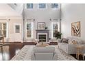 Bright living room with high ceilings, fireplace, and large windows overlooking the backyard at 407 Mountain View Ln, Woodstock, GA 30188