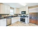 Well-lit kitchen featuring white cabinets, stainless steel appliances, and a window over the sink at 30 Freedom Ne Dr, Cartersville, GA 30121