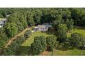 An aerial view of a two story home with a large pool, long drive, and mature trees at 450 Ledbetter Rd, Villa Rica, GA 30180