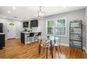Bright dining area with a modern table, wood floors, and an open layout to the kitchen at 1788 Campbellton Sw Rd, Atlanta, GA 30311