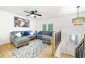 Bright living room features hardwood floors, a ceiling fan, and a comfortable gray sofa at 2099 Redbud Sw Ct, Marietta, GA 30008