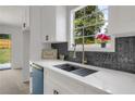 Bright kitchen features white cabinets, white countertops, stainless steel sink, and decorative backsplash at 8689 Cedar Creek Rdg, Riverdale, GA 30274