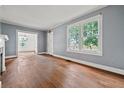 An empty living room with wood floors, light blue walls, two windows and white trim at 10 Shadburn Ferry Rd, Buford, GA 30518