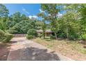 Brick home with a covered porch and an extended driveway surrounded by trees and green space at 1737 Fontaine Dr, Jonesboro, GA 30236