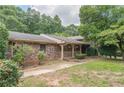 Charming brick home featuring a cozy covered porch with decorative railing and landscaped lawn at 1737 Fontaine Dr, Jonesboro, GA 30236