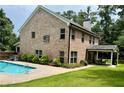 Brick house showcasing outdoor living, complete with a pool, hot tub, and covered patio area at 115 Green Valley Cir, Mcdonough, GA 30252