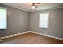 Inviting bedroom with modern ceiling fan, hardwood-style flooring, and two windows for natural light at 1621 Oak Rd, Snellville, GA 30078