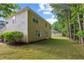 Expansive back yard with a two-story tan home with a partial view of the side of the house at 7567 Waverly Loop, Fairburn, GA 30213