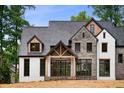 Newly built home with a painted brick and stone exterior showcasing modern farmhouse architectural details at 3661 Clubwood Trl, Marietta, GA 30068