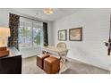 Cozy office with a light desk, brown leather stools, light colored walls, and a large window at 722 Ocmulgee Xing, Locust Grove, GA 30248