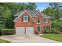 Charming two-story brick home features a well-manicured lawn and an attached two-car garage at 1015 Legacy Walk, Woodstock, GA 30189