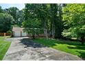Exterior view of home with a long driveway and lush greenery at 5070 Maryland Nw Dr, Acworth, GA 30101