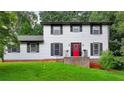 Charming two-story home featuring a bright red front door, black shutters and a lush green lawn at 4756 Manly Ct, Stone Mountain, GA 30088
