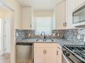 Modern kitchen featuring granite counters, stainless steel appliances, and updated white cabinets at 2391 Cove Rd, Lithonia, GA 30058