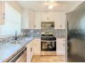 Updated kitchen with granite countertops, stainless steel appliances, and a mosaic backsplash at 2391 Cove Rd, Lithonia, GA 30058