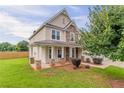 Attractive house featuring a covered front porch, stone accents, and a well-manicured lawn with mature landscaping at 70 Trinity Lane, Covington, GA 30016