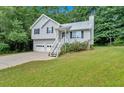 Picturesque light-gray home with a well-manicured lawn, two-car garage, and welcoming front entrance at 50 Old Oak Trce, Dallas, GA 30157